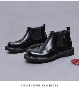 Dettaglio di stivali Chelsea Brogue in pelle nera con elastico e papillon rosso elegante