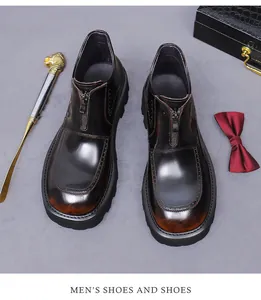 Detailed close-up of glossy leather brogue boots with front zipper and gradient toe finish