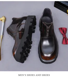 Detail view of glossy brown leather boots with front zipper and brogue carving texture