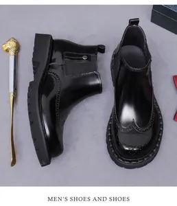 Dettaglio degli stivali Chelsea da uomo in pelle nera con decoro brogue e suola spessa in gomma