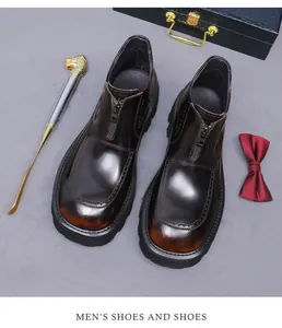 Close-up of polished cowhide leather men's boots with front zipper and vintage brogue detailing