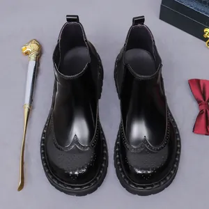 Stivali Chelsea in pelle nera lucida con intaglio brogue su sfondo business raffinato