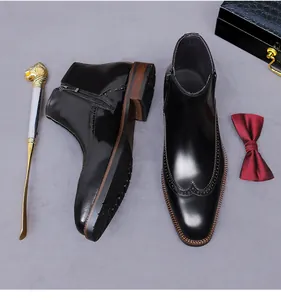 Makro-Detail von glänzenden schwarzen Brogue-Boots für Herren mit feiner Flügelgravur