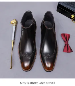 Detailansicht der Brogue-Flügelkappe auf glänzenden Chelsea-Boots aus Leder in Schwarzbraun