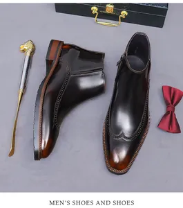 Detail der Brogue-Flügelkappenschnitzerei und glänzende Ledertextur auf Chelsea-Boots