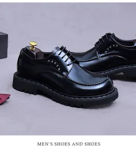 Detail eines glänzenden schwarzen Derby-Schuhs aus Leder mit Nieten und dicker Gummisohle