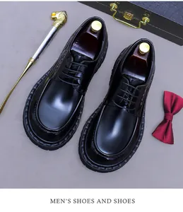 Nahaufnahme glänzender schwarzer Lederschuhe mit roter Fliege und exklusivem Zubehör