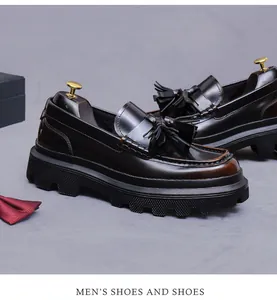 Detail of dark brown polished leather loafers with stylish tassel and thick platform sole
