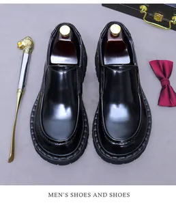 Detail eines glänzenden schwarzen Leder-Loafers mit dicker rutschfester Sohle und Zubehör
