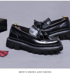 Detail view of black glossy leather loafers with classic tassels and thick platform soles