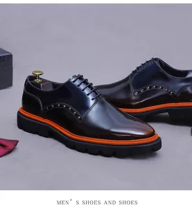 Detail of color-block leather derby shoe with metal studs and orange platform sole