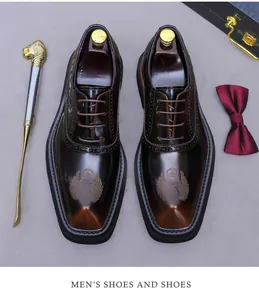 Detail von dunkelbraunen Leder-Derbyschuhen mit Kronenstickerei und Business-Accessoires