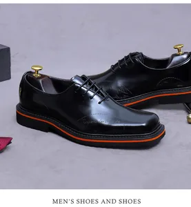 Dettaglio scarpa oxford in pelle nera con striscia arancione sulla suola e goffratura