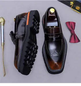 Dettaglio di mocassini in pelle sfumata marrone con motivi brogue e suola spessa in gomma