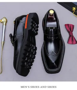 Dettaglio di mocassini in pelle nera con motivi brogue e suole spesse arancioni