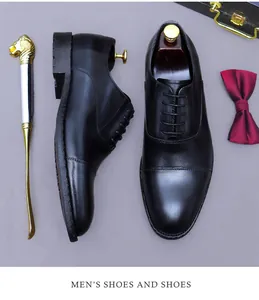 Primer plano de zapatos Oxford de cuero negro con pajarita roja y calzador de lujo