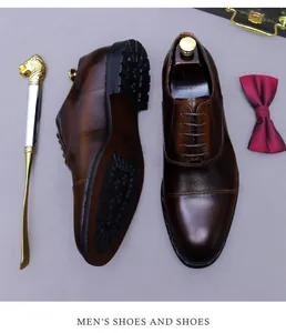 Vista plana de zapatos Oxford de cuero marrón con pajarita roja y calzador de león