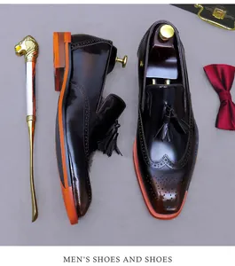 Vista dall'alto di scarpe brogue da uomo in pelle marrone scuro con nappe e suola arancione