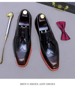 Dettaglio macro di scarpe brogue da uomo in pelle bordeaux con nappe e suola arancione