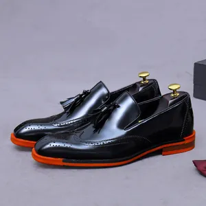 Mocassini brogue da uomo in pelle con nappe decorative e suola arancione brillante alla moda