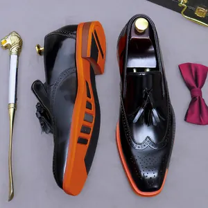 Brogue da uomo in pelle con intaglio wingtip nero, nappe e suole arancioni