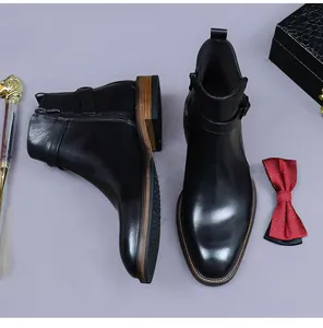 Gros plan détaillé sur les bottines Chelsea en cuir noir avec zip latéral et boucle métallique