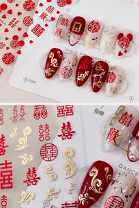 Macro detail of red and gold Chinese wedding nail stickers with Xi character and crane