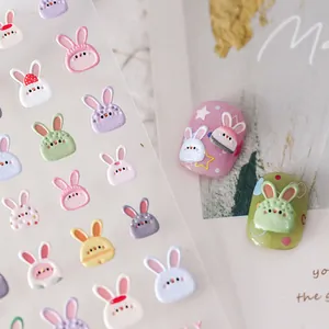 3D Macaron bunny nail stickers and resin charms in multiple colors on a matte background