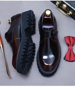 Detail eines burgunderroten Monkstrap-Leder-Schuhs mit Metallschnalle und Plateausohle