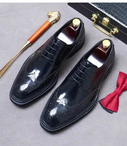 Detalle de zapatos brogue de cuero negro con perforaciones y accesorios de lujo