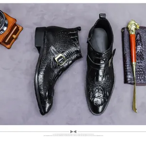 Détail de botte en cuir noir à motif crocodile avec boucle dorée et fermeture éclair