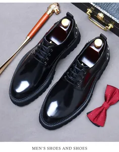 Detail of black patent leather derby shoes with metallic rivets and platform soles
