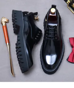 Detail of glossy black leather derby shoes with metallic studs and thick rubber soles