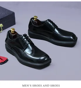 Detail von schwarzen Derby-Lederschuhen mit roter Fliege und Schuhspannern in einer Geschenkbox
