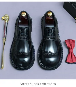 Detail der schwarzen Brogue-Lederschuhe mit Wingtip-Lochmuster und Schnürung