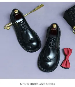 Detailansicht der schwarzen Brogue-Schuhe aus Leder mit Flügelkappe und edlem Zubehör