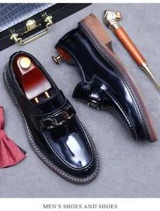 Close-up of black patent leather loafers with metal chain and premium wooden shoe tree