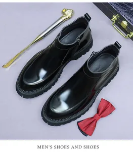 Close-up of polished black leather chelsea boots with thick sole and side zipper detail