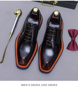 Detalle de zapatos oxford en cuero marrón brillante con suela con borde naranja y accesorios