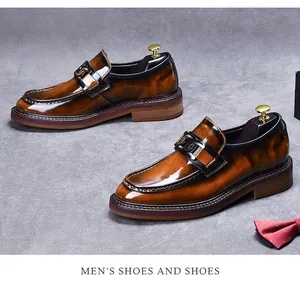 Top-down view of premium brown leather loafers with gold buckles and wood-grain soles