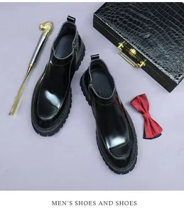 Close-up of black glossy leather Chelsea boots with side zipper and thick lug sole