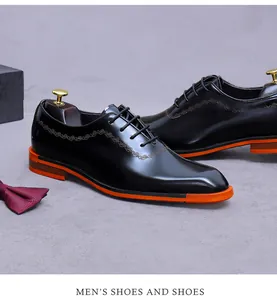 Détail d'une chaussure en cuir verni noir avec semelle orange vif et coutures élégantes