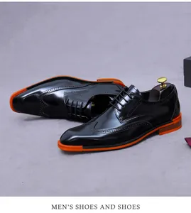 Detail of black glossy leather brogue shoes for men featuring vibrant orange thick soles