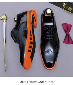 Detail of black leather brogue shoes with vibrant orange soles and gentleman accessories