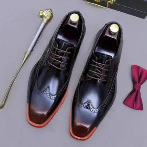 Polished brown leather brogue shoes with orange sole accent and intricate wingtip details