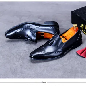 Classic black leather loafers for men featuring brogue detailing and stylish tassels