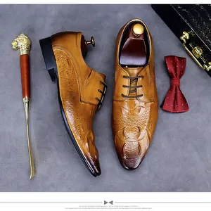 Vue à plat de chaussures Oxford en cuir croco marron avec chausse-pied lion et nœud papillon