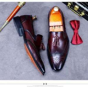 Top view of dark brown leather tassel loafers with classic brogue detailing and menswear props