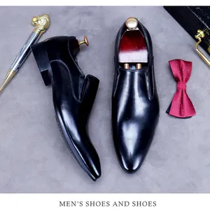 Top-down view of black leather loafers with shoe trees, shoehorn and business accessories