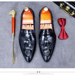 Detail of black crocodile embossed leather loafers with tassels and wooden shoe tree